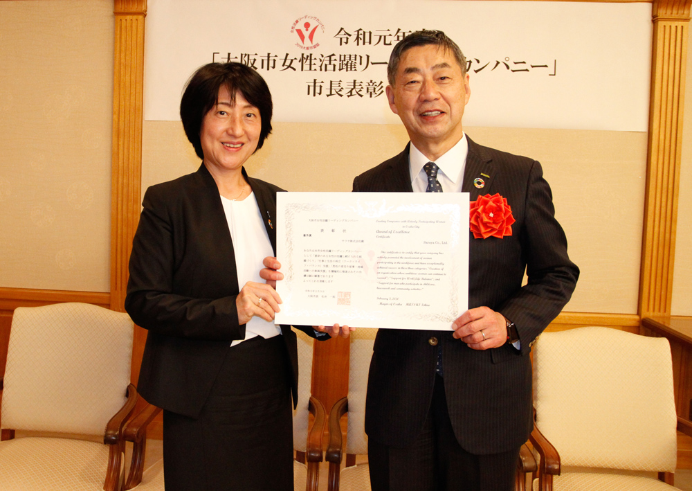 HR Director Murai with President Saraya, holding the "Leading Companies with Actively Participating Women in Osaka City" Award