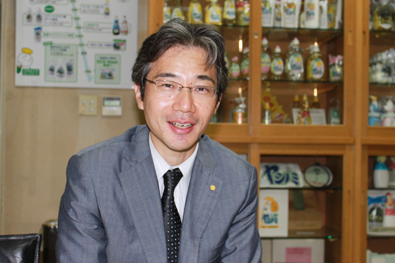 Dr. Hirata, posing in front of SARAYA’s Yashinomi bottles over the years. Photo taken in 2010. 